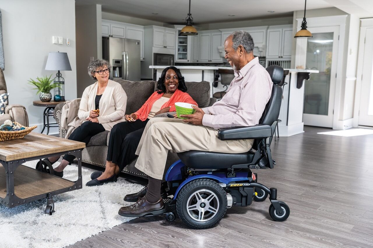 Man using powered mobility while visiting with others